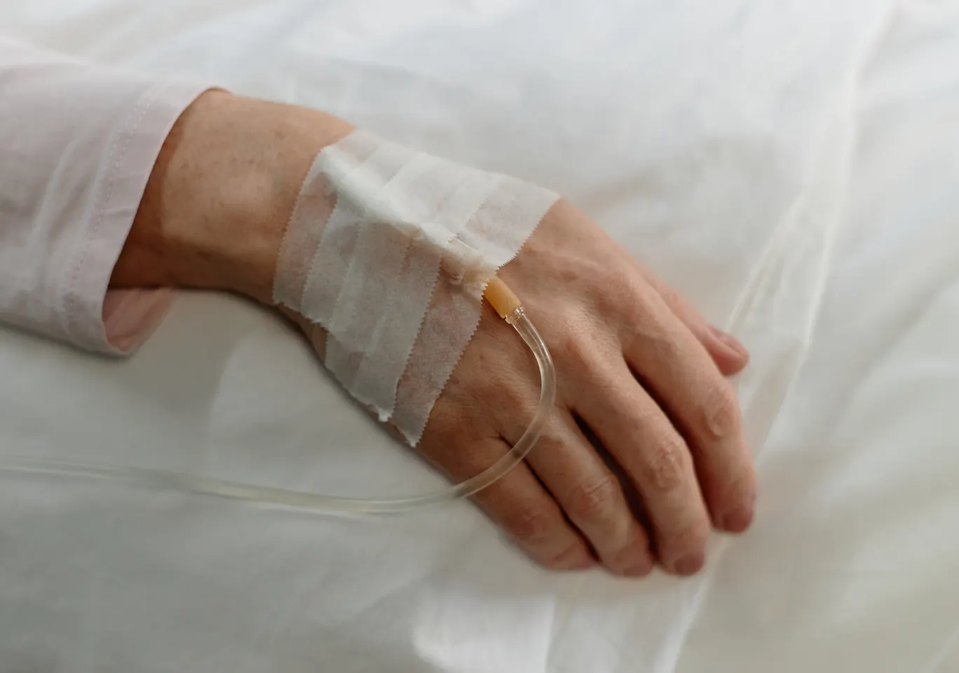 Kroplówki witaminowe Bartoszyce: dłoń z podłączoną kroplówką w spokojnym kadrze