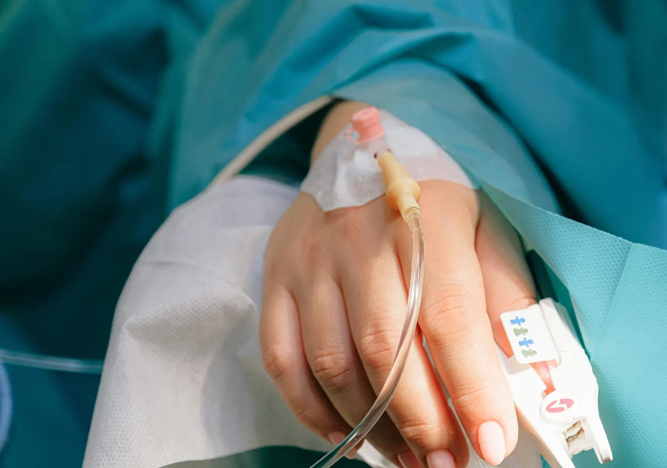 Detoks alkoholowy Działdowo: dłoń z wenflonem i pulsoksymetrem pod nadzorem
